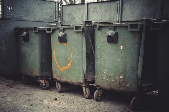 Old Green Dumpsters On The Street. Household Waste In The City.