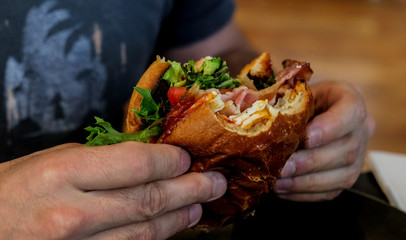 Man holding burger with bites taken out
