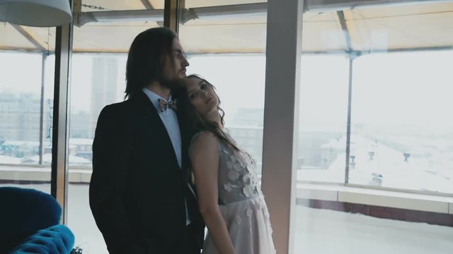Bridal couple hugging by the window in slow-motion