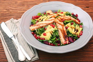 Salad with fried salmon, avocado and pomegranate seeds. Low fat healthy eating concept.
