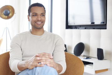 Confident young man portrait. Shot of a young Afro American man sitting at home and relaxing.