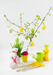 Easter composition of the color of its hanging from the birch branches with leaves, two rabbits and care for the garden