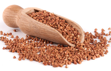 Buckwheat in a wooden scoop isolated on white background