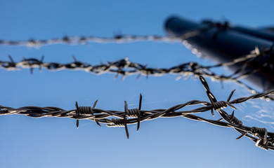 Strands of barbed wire on top of security fence