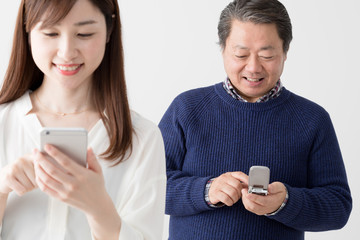 娘のスマートフォンを羨ましがる父親、親子、