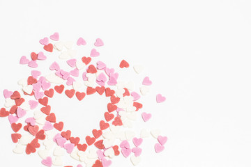 Sugar sprinkles ice top bakery. Glaze confectionery decoration for the cake pie or ice cream. Valentines Day candy heart background of colorful  sprinkles spilled from a glass jar on white table.