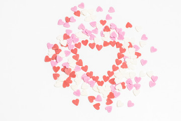 Sugar sprinkles ice top bakery. Glaze confectionery decoration for the cake pie or ice cream. Valentines Day candy heart background of colorful  sprinkles spilled from a glass jar on white table.