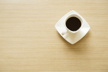 espresso coffee in white modern mug on wooden table in the morning
