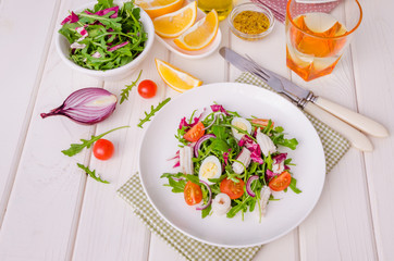 Salad with arugula, squid, cherry tomatoes, onion and quail eggs
