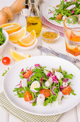 Salad with arugula, squid, cherry tomatoes, onion and quail eggs