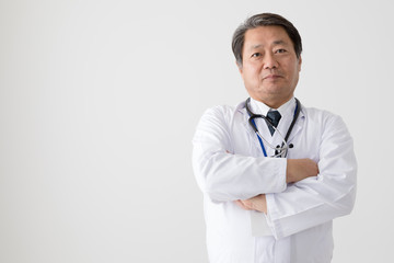 腕組みをする医者、中年男性