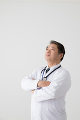 腕組みをする医者、中年男性