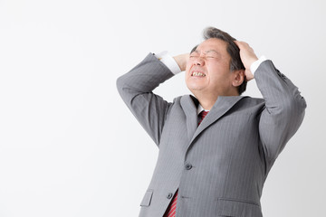頭をかかえるビジネスマン、中年男性