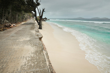 Road along beautiful coast of tropical island during rainy day