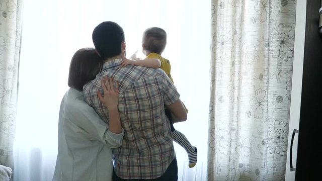 Happy family is standing by the window. Family concept. Full Hd Slow Motion Stock Footage.
