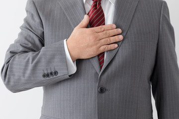 胸に手を当てるビジネスマン、中年男性