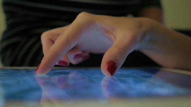 Female hand uses tablet for maps and geoposition.
