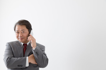 携帯電話で通話するビジネスマン、中年男性