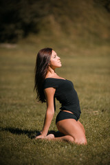 Fototapeta na wymiar pretty girl performing fitness activities and stretching on the lawn
