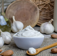 Pine nut mayonnaise or soy almond homemade vegan garlic mayo or bechamel white sauce on rustic rural wooden background.