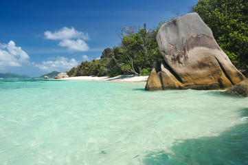 Big granite stones on the white-sand beach next to turquoise water
