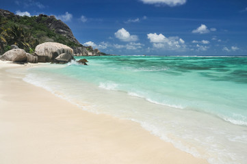 Big granite stones on the white-sand beach next to turquoise water