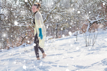 Cute fashion Girl barefoot on white cold snow in winter. Quenching tempering harding health concept. Female feet without shoes. Healthy and Strong organism