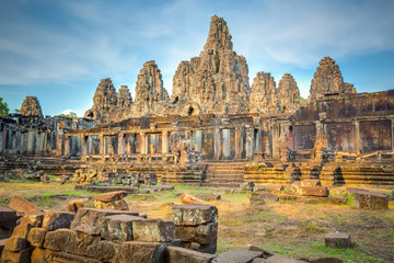 Main view of ancient Bayon temple in Angkor Thom in evening sun. Mysterious Angkor Thom nestled among rainforest in Siem Reap, Cambodia. Enigmatic Angkor Thom is a popular tourist attraction.