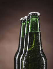 Glass bottles of beer on brown background