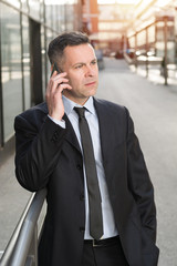 Serious businessman talking on cell phone