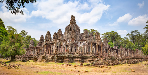 Fototapeta na wymiar Bayon temple in Angkor Thom. Mysterious Angkor Thom nestled among rainforest in Siem Reap, Cambodia. Enigmatic Angkor Thom is a popular tourist attraction.