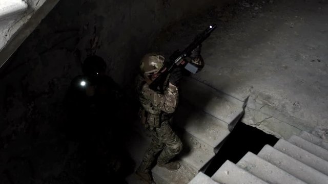 Military men with arms defend the building and go up the stairs