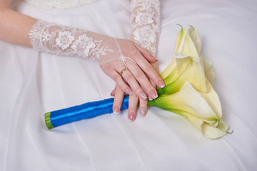 bride is holding a wedding bouquet of callas
