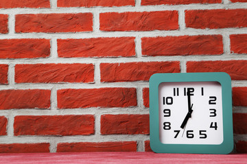 Fototapeta na wymiar Green clock on a brick wall background