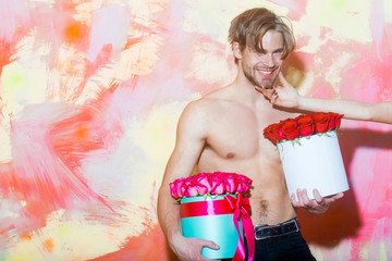 Naklejka premium bearded muscular man with sexy body holds red rose box