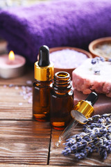 Lavender oil with soap and flowers on brown wooden table