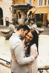 Young couple in love hugging near the fountains in Rome