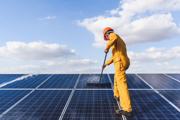 Worker cleaning solar panels