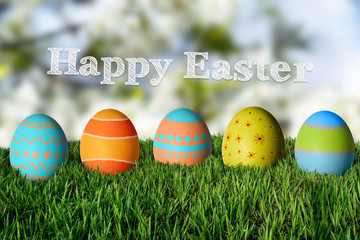 Inscription Happy Easter and painted colorful eggs in the grass.