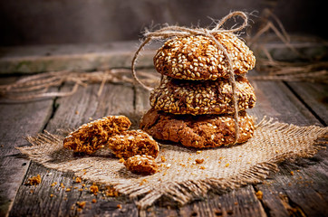 Homemade cookies with sesame, dark wood background, selective focus