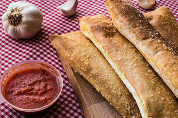 Garlic bread sticks with tomato sauce and parmesan cheese.
