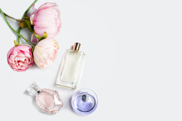 Perfume bottles with flowers on light background. Perfumery, cosmetics, fragrance collection. Free...