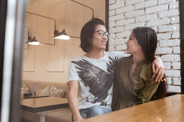 Cheerful asian young loving couple at the cafe.