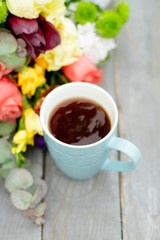 Morning Cup of coffee and a beautiful roses flowers on light background, top view. Cozy Breakfast. Flat lay style.