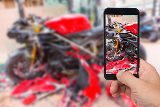 Close up hand  holding smartphone and take photo of motorbike accident