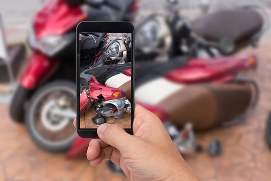 Close up hand  holding smartphone and take photo of motorbike accident