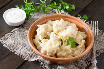 Dumplings with cabbage and ham are served with sour cream sauce, a recipe for diet food.