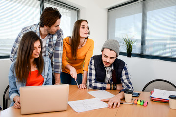 Obraz premium group of four young business people man and woman in casual wear working in a creative business startup company office