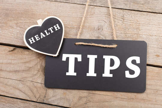 blackboard with text "Health tips" on wooden background