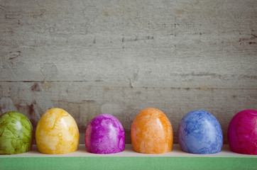 Ostereier, nebeneinander, in einer Reihe, bunt, Hintergrund Holz, Textfreiraum